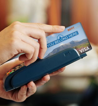 person swiping a bangor federal visa credit card