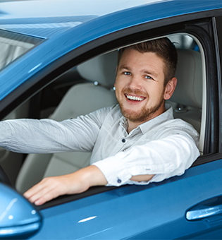 man smiling in new car